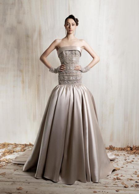 Strapless beige beaded bodice ball gown with  voluminous satin skirt and short beaded gloves