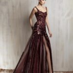 Burgundy sequined gown with sheer panels and high slit
