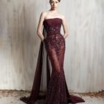 Burgundy strapless gown with intricate beading and sheer train