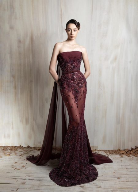 Burgundy strapless gown with intricate beading and sheer train