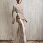 Off-shoulder champagne gown with a sculpted peplum bodice