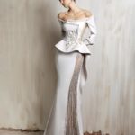 Off-shoulder off - white gown with a structured peplum bodice