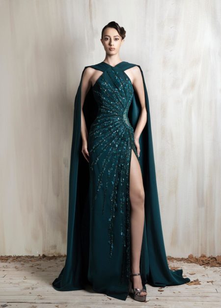 Emerald halter gown with beaded draping and a flowing cape.