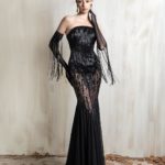 Black strapless lace gown with sheer gloves and fringe details.