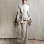 Elegant off - white gown with lace detailing and cinched waist.