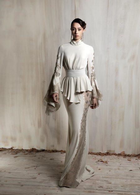 Elegant off - white gown with lace detailing and cinched waist.