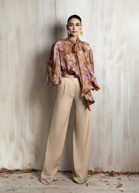Printed silk blouse paired with relaxed beige wide-leg trousers