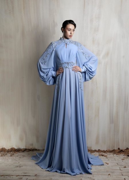 Powder blue gown with embroidered cape sleeves.