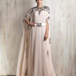 Soft blush cape gown with intricate silver embroidery.